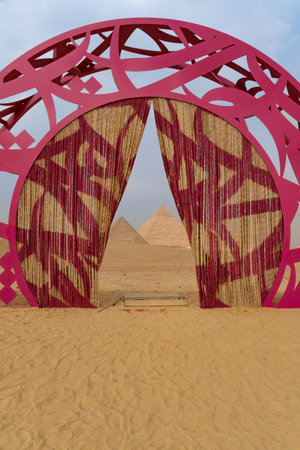 Sculpture in the middle of the desert, with the pyramids of Giza just behind.のeditorial素材