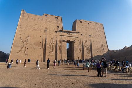 Edfu temple exterior with some tourists, photo taken at sunrise