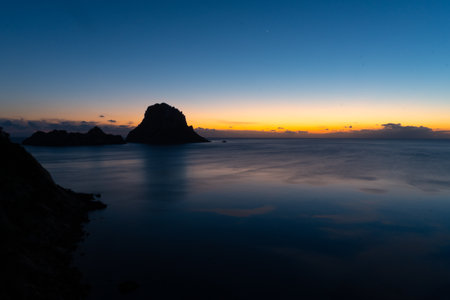 Sunset in Es VedrÃ  on the island of Ibiza, with few clouds, with the silhouette of the islet of Es VedrÃ の写真素材