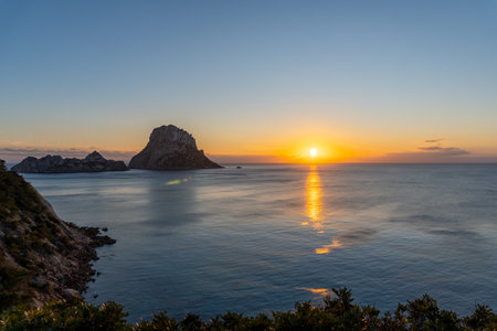 Sunset in Es VedrÃ  on the island of Ibiza, with few clouds, with the silhouette of the islet of Es VedrÃ の写真素材