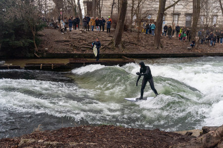 Person surfing in an artificial wave, in the Isar river in the city of Munich.のeditorial素材