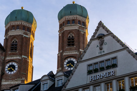 Towers of the Munich cathedral, with a German type house in front, at sunrise.のeditorial素材