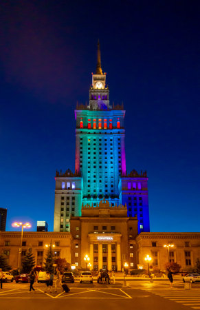 Palace of Culture and Science in the city of Warsaw at night with the illumination of many different colorsのeditorial素材