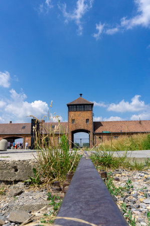 Auschwitz concentration camp, with the tracks where the prisoners' trains passed, on a sunny day with some clouds.のeditorial素材