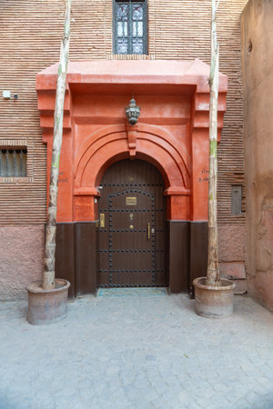 Moroccan house door in the city of Marrakech on a sunny day. Terracotta colored walls.の写真素材