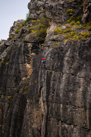 A strong man climbs a rock. Climbing in the mountains.の写真素材