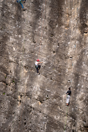 Rock climber ascending a challenging route on a rocky wall. Extreme sport.の写真素材