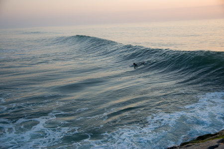 Surfer in the ocean at sunset. Surfer on the beach.の写真素材