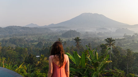 Young woman looking at the beautiful view of Mount Agung in Bali, Indonesia