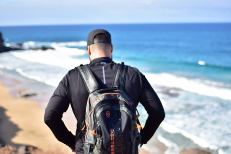 Young man with a scuba diving suit standing on the beach.