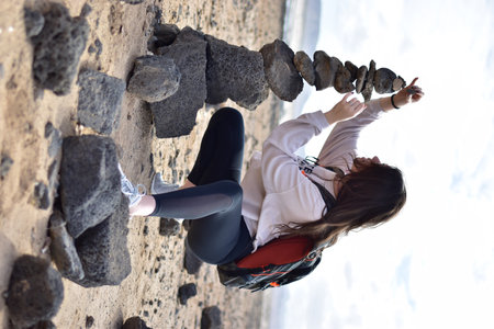 Young woman climbing on a rock wall in the winter, view from aboveの写真素材