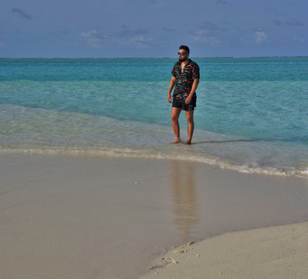 young man standing on the beach in the caribbean sea of dominican republicの写真素材