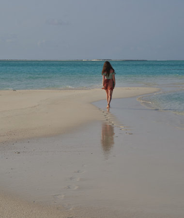 Woman walking on the beach in the tropics, Maldives.の写真素材