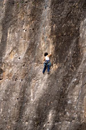 A girl climbs a rock. Climbing on a natural terrain.の写真素材