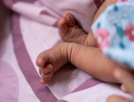 Close-up of a newborn baby's feet on a pink blanket