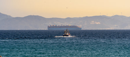 Panoramic view of the sea and the cargo ship at sunsetの写真素材