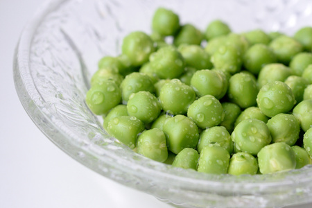 A bowl of fresh wet green peasの写真素材