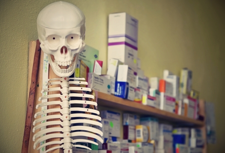 Skeleton with pills in the background