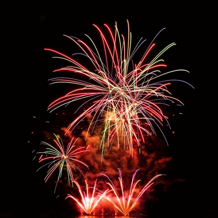 Beautiful colorful fireworks on the water surface with a clean black background. Fun festival and international contest of Firefighters from all over the world Ignis Brunensis 2017. Brno Dam - Czech Republic.の写真素材