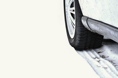 Car in winter. Tire on a snowy road in bad weather.の写真素材