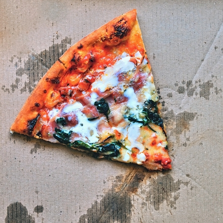 Excellent fresh pizza with cheese, bacon and spinach in a box. Delivery of food on the phone to the house.の写真素材