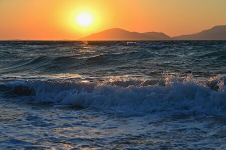Beautiful sunset with sea and waves. Natural colorful background. Concept for summer and sea vacation. Greece - island of Kos.の写真素材
