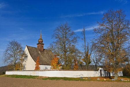Beautiful autumn landscape with old Chapel of the Mother of God in Veveøí. Sunset and beautiful blue sky with clouds. Colorful nature background on autumn season. Brno - Czech Republic.の写真素材