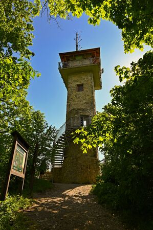 Beautiful stone lookout tower in the forest with trees and blue sky and sun. Alexander Lookout Tower - Adamov - Czech Republic.の写真素材