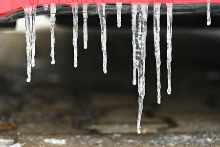 Beautiful icicles on the car. Concept for winter and dangerous winter traffic of cars on the road.