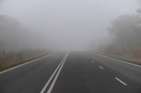 Bad weather driving - foggy hazy country road. Motorway - road traffic. Winter time.の写真素材