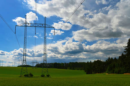 High voltage pylons - Blue sky with clouds and sun in nature. Concept for technology and industry. Further rising electricity and energy prices - the energy crisis caused by the war between Russia and Ukraine.の写真素材