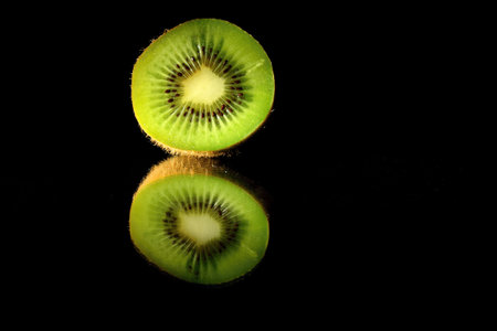 Kiwi fruit isolated on black background with reflection and copy spaceの写真素材