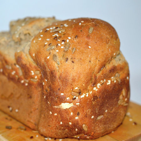 loaf of bread with sunflower and sesame seeds on wooden board