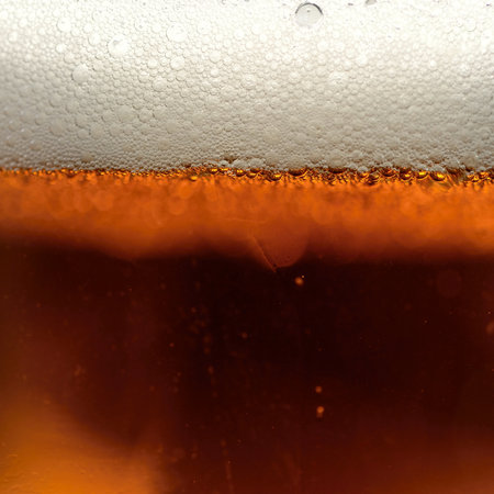 Close-up of beer in a glass with foam and bubbles.の写真素材