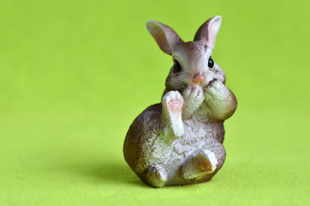 Easter bunny figurine on green background with copy space for textの写真素材