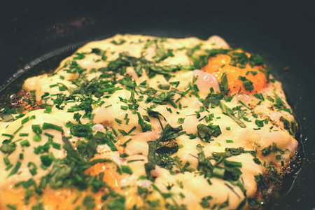 fried eggs with herbs in a frying pan with filter effect retro vintage styleの写真素材