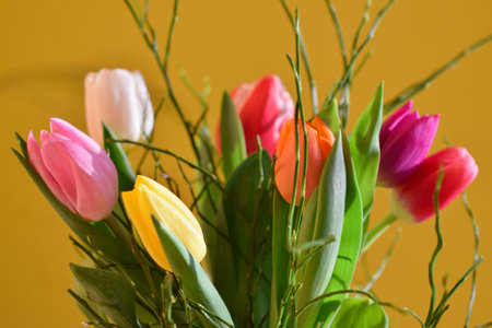 Bouquet of tulips in a vase on a yellow backgroundの写真素材