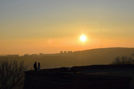Silhouette of a couple against the backdrop of the setting sunの写真素材