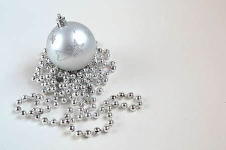 Silver christmas ball with beads on a white background, closeup of photoの写真素材
