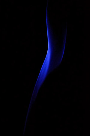 blue smoke from incense stick on a black background close-upの写真素材