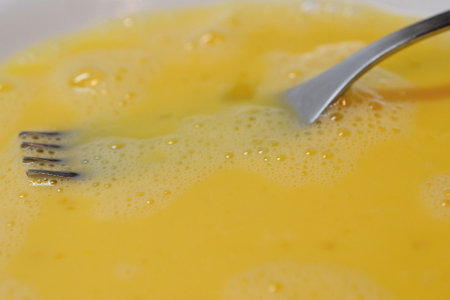 Close up of a bowl of yellow egg yolks with a spoon