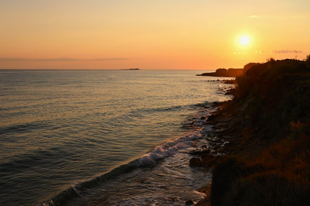 Beautiful sunset on the beach with the sea. Greece - island of Corfu (Kerkyra). Concept for travel, holidays and summer vacations.の写真素材