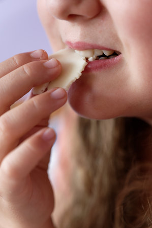 Young girl - child eating candy and sweets. Detail of face and mouth. Concept for healthy lifestyle...