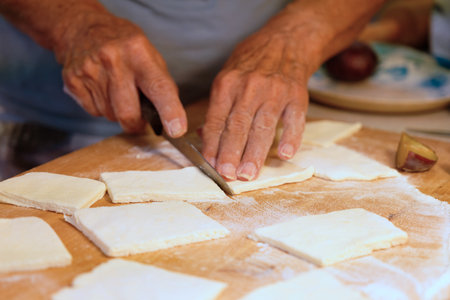Preparation of homemade fruit dumplings with plums. Czech specialty of sweet good food. Dough on...