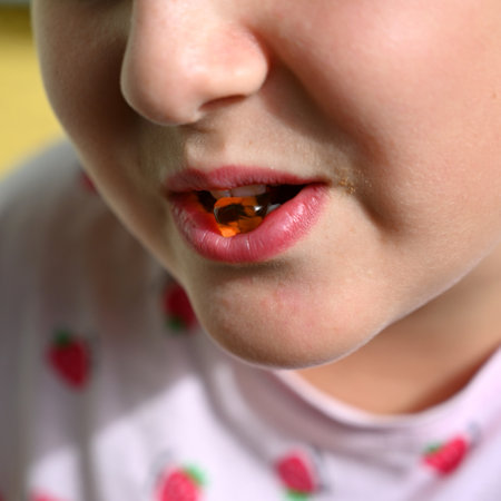 Young girl - child eating candy and sweets. Detail of face and mouth. Concept for healthy lifestyle - healthy - unhealthy sweet food and sugar.の写真素材