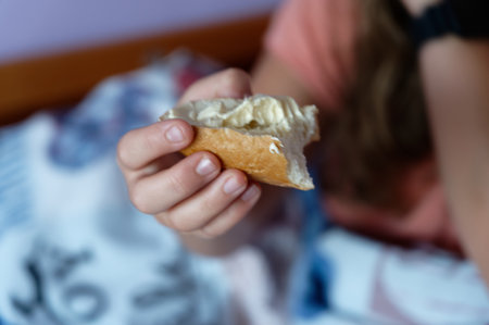 Girl eating a sandwich in bed. Selective focus. Food.