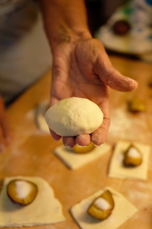 Close-up of the hands of a woman kneading dough on a baking sheetの写真素材
