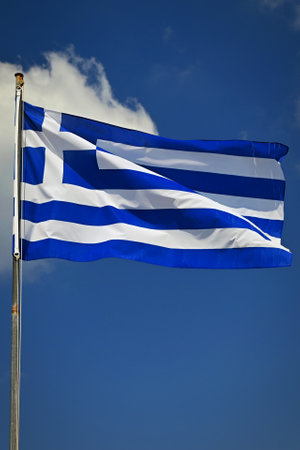 Flag of Greece Flying in Wind and Blue Sky. Summer background for travel and holidays.
