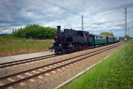 Old Czech historical steam train with wagons driving on the tracks for a trip. Concept for railways...