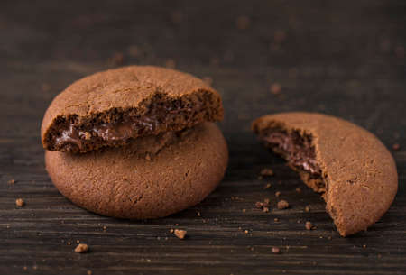 Chocolate cookies with liquid chocolate filling on a wood board